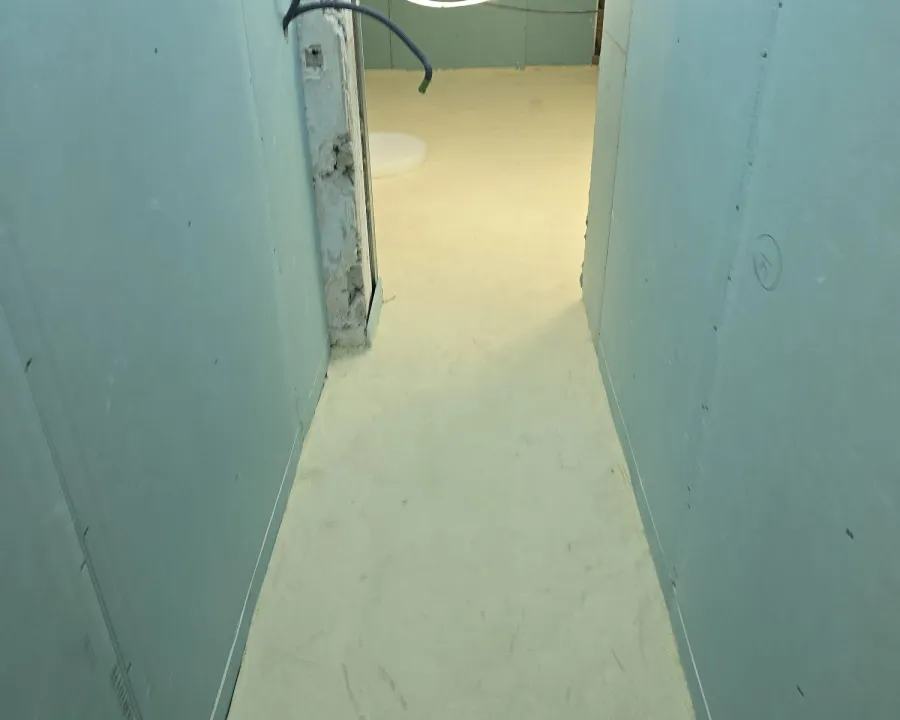 Couloir étroit au sol isolé entre deux cloisons — villa au Cap d’Antibes