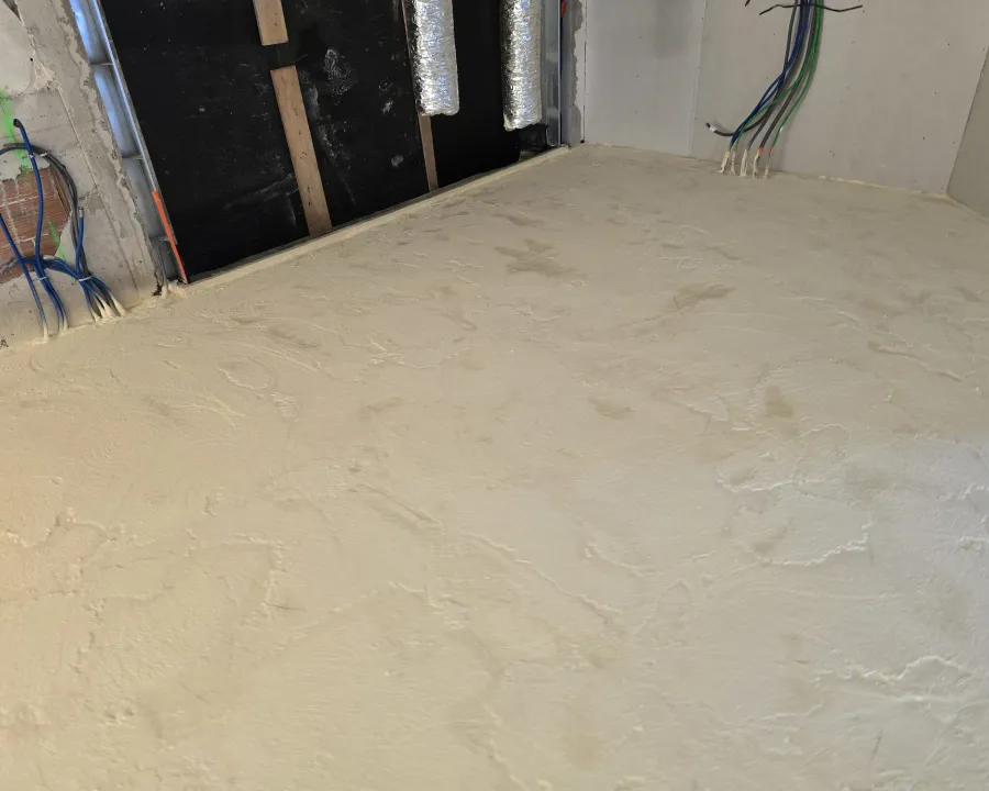 Sol isolé au pied d’une paroi en cours de travaux, gaines et câbles apparents — villa au Cap d’Antibes