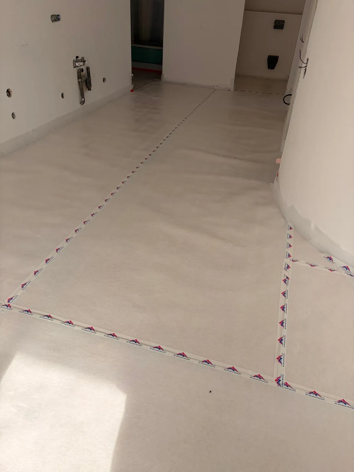 Détail de la sous-couche acoustique au sol et de ses raccords sur le chantier à Auron